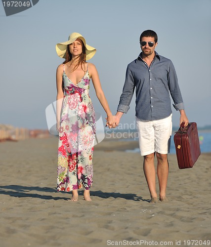 Image of couple on beach with travel bag