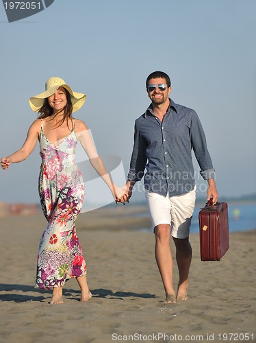 Image of couple on beach with travel bag