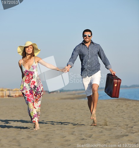 Image of couple on beach with travel bag