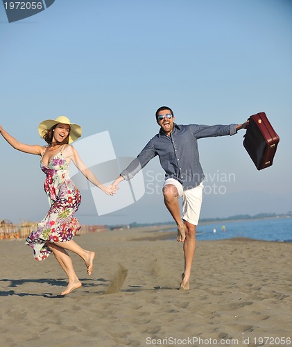 Image of couple on beach with travel bag