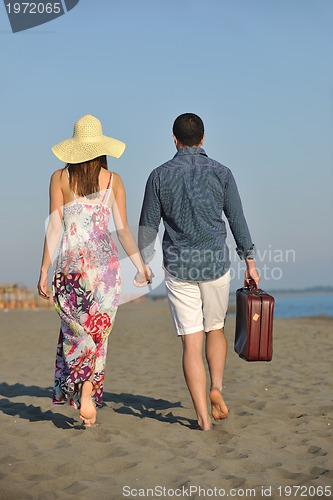 Image of couple on beach with travel bag
