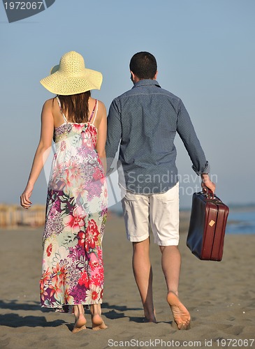 Image of couple on beach with travel bag