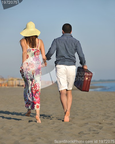 Image of couple on beach with travel bag