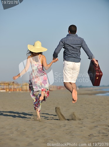 Image of couple on beach with travel bag