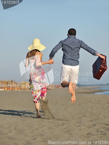 Image of couple on beach with travel bag