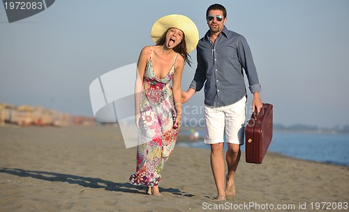 Image of couple on beach with travel bag