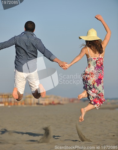 Image of couple on beach with travel bag