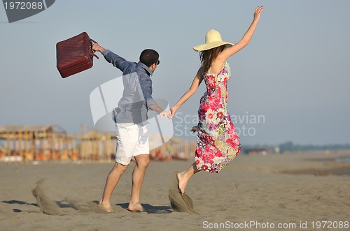 Image of couple on beach with travel bag