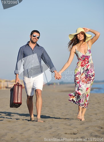 Image of couple on beach with travel bag