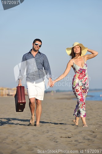 Image of couple on beach with travel bag