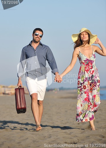 Image of couple on beach with travel bag