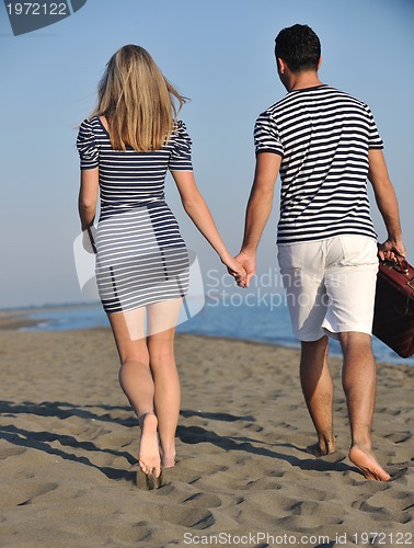 Image of couple on beach with travel bag