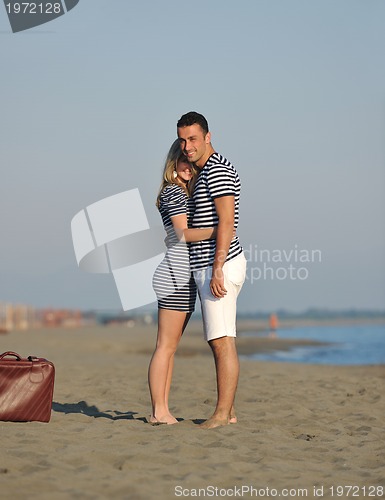 Image of couple on beach with travel bag