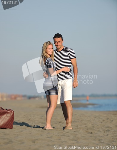 Image of couple on beach with travel bag