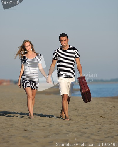 Image of couple on beach with travel bag