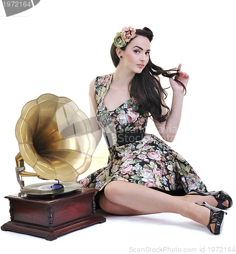 Image of pretty girl listening music on old gramophone