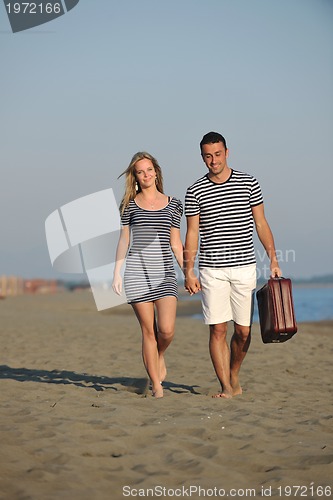 Image of couple on beach with travel bag