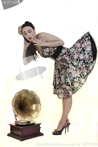 Image of pretty girl listening music on old gramophone