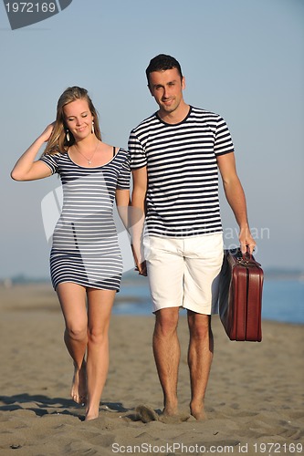 Image of couple on beach with travel bag