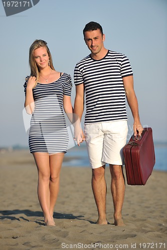 Image of couple on beach with travel bag