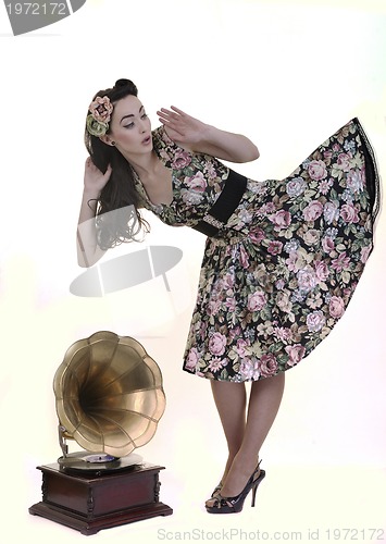 Image of pretty girl listening music on old gramophone