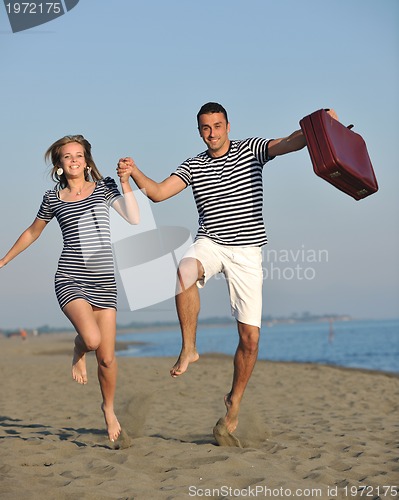 Image of couple on beach with travel bag