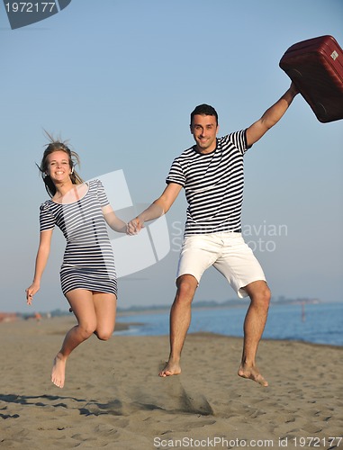 Image of couple on beach with travel bag