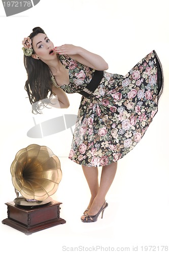 Image of pretty girl listening music on old gramophone