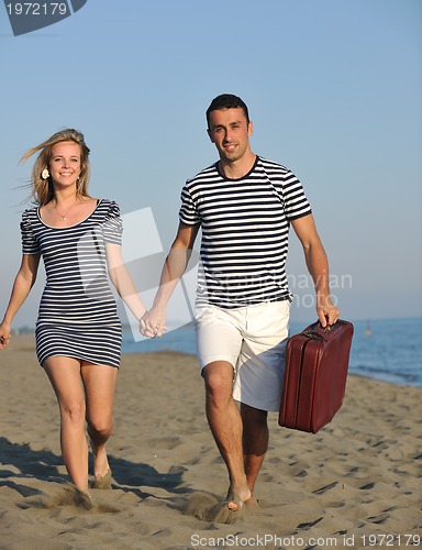 Image of couple on beach with travel bag