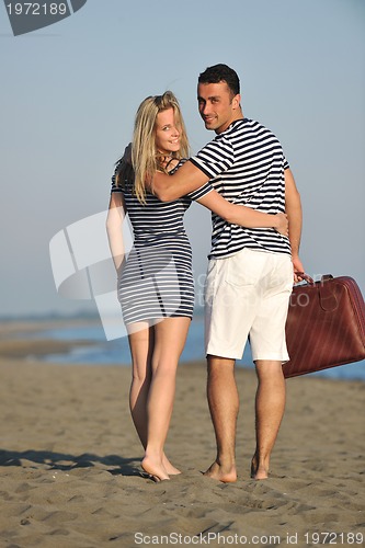 Image of couple on beach with travel bag