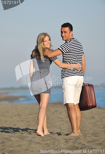 Image of couple on beach with travel bag