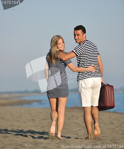 Image of couple on beach with travel bag