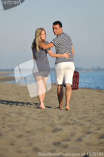 Image of couple on beach with travel bag
