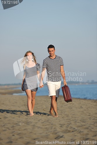 Image of couple on beach with travel bag
