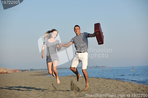 Image of couple on beach with travel bag