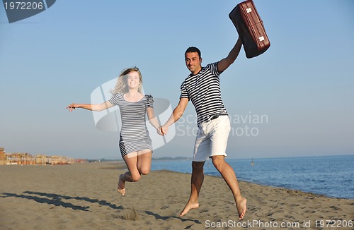 Image of couple on beach with travel bag