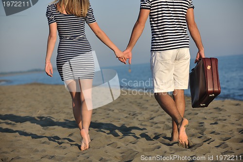 Image of couple on beach with travel bag