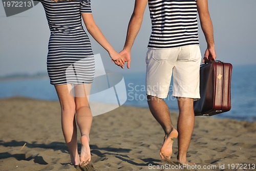 Image of couple on beach with travel bag