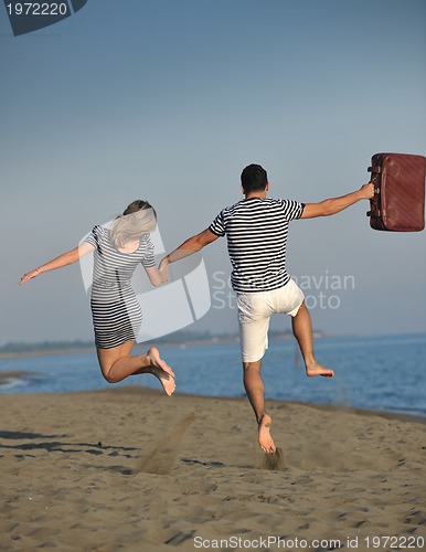 Image of couple on beach with travel bag