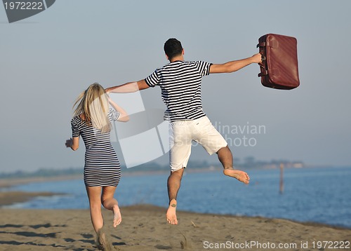 Image of couple on beach with travel bag