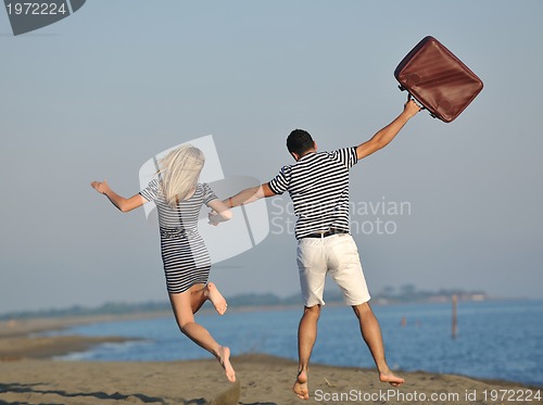 Image of couple on beach with travel bag