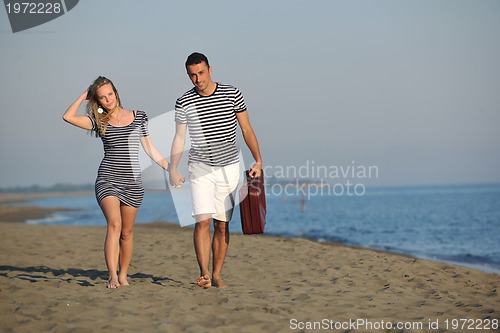 Image of couple on beach with travel bag
