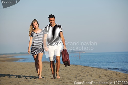 Image of couple on beach with travel bag