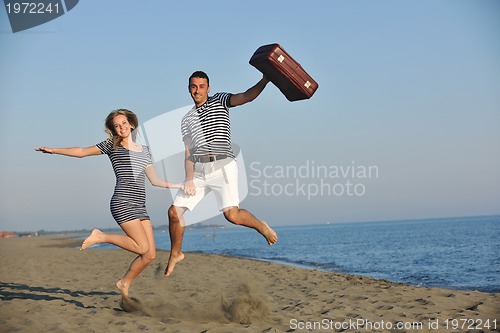 Image of couple on beach with travel bag