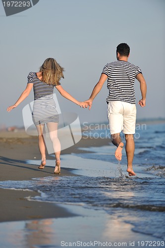 Image of happy young couple have romantic time on beach
