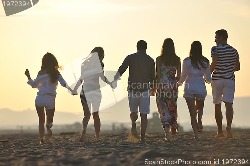 Image of Group of happy young people in have fun at beach