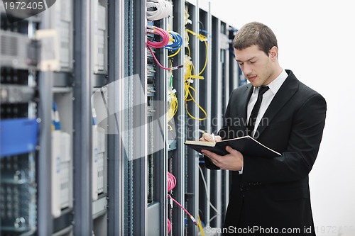 Image of it businessman withnotebook in network server room