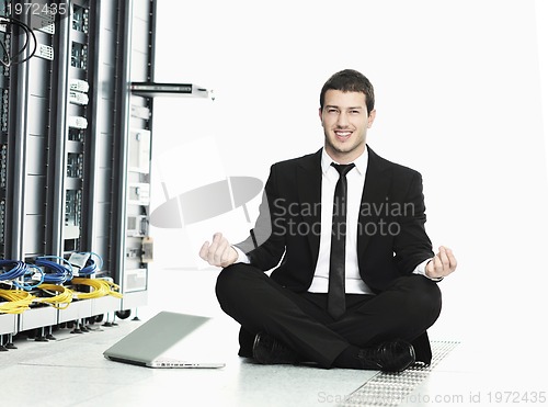 Image of business man practice yoga at network server room