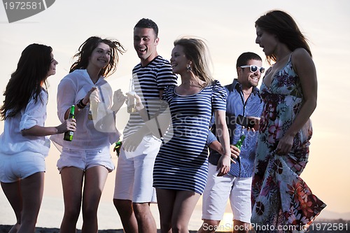 Image of Group of young people enjoy summer  party at the beach