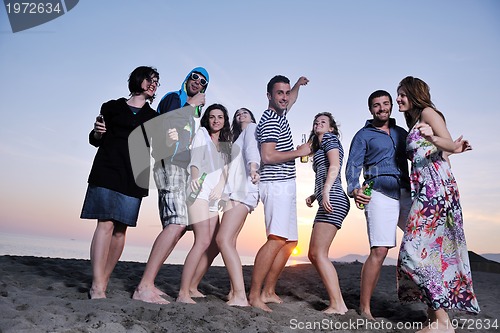 Image of Group of young people enjoy summer  party at the beach